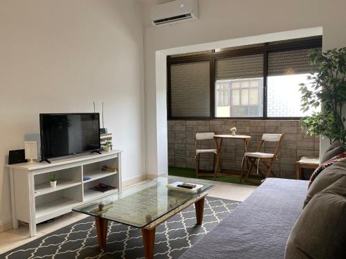 a living room with a tv and a coffee table at Barreiro Central Apartment in Barreiro