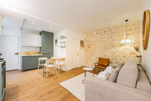 un salon avec un canapé et une cuisine dans l'établissement Lovely Flat-4 Pers-Sacré Cœur-Montmartre, à Paris
