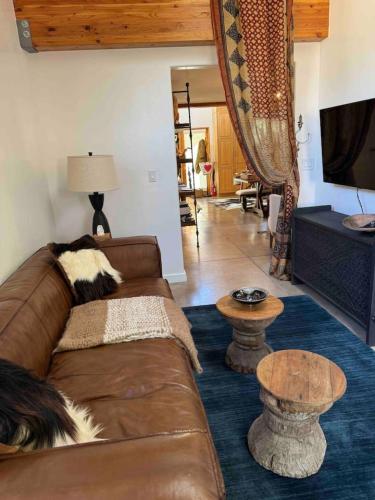 a living room with a brown couch and a table at CASA TUA SANTA FE 2BR 2BA Design Loft Yoga studio Outdoor Living in Santa Fe