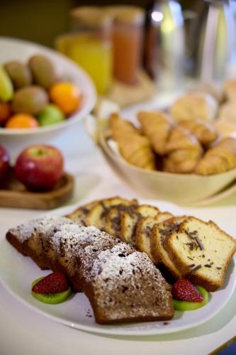 a plate of food with bread and fruit on a table at Domotel Olympia in Thessaloniki