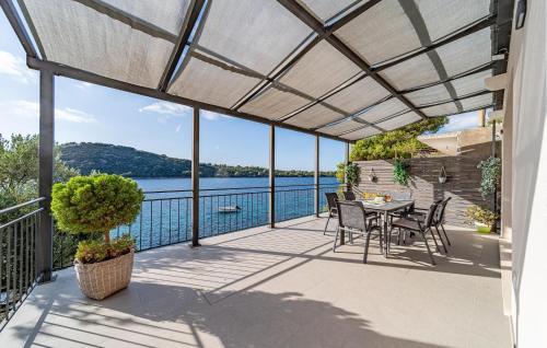 Un patio con mesa y sillas y vista al agua. en Nice Home In Karbuni With Wifi, en Brnistrova