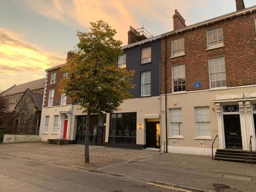 a building on a street with a tree in front of it at The Auction House in Belfast