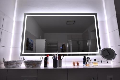 a bathroom with a large mirror above a sink at Elegantes & modernes Apartment NeLi mit Terrasse, 100m zum Hafen Röbel Müritz in Röbel