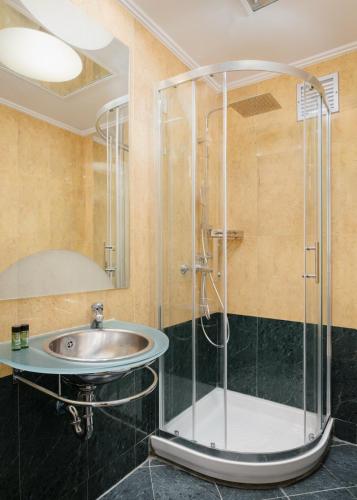 a bathroom with a sink and a shower at Kreoli Hotel in Athens