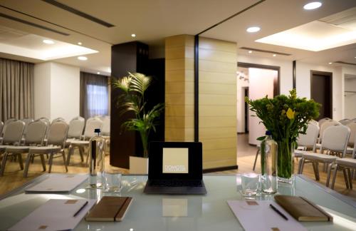 a laptop sitting on a table in a room with chairs at Domotel Olympia in Thessaloniki