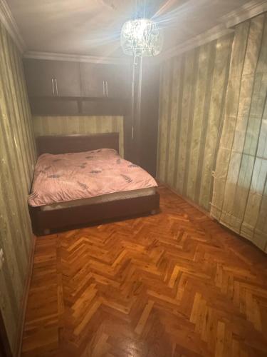 ein kleines Schlafzimmer mit einem Bett und einem Kronleuchter in der Unterkunft Home in Baku