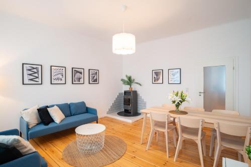 a living room with a blue couch and a table at Arbio Monteurzimmer Fredersdorf parking included in Altlandsberg-Süd