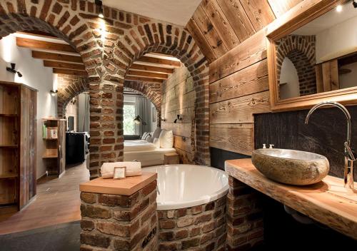 a bathroom with a stone tub and a sink at Hotel Land Gut Höhne in Mettmann