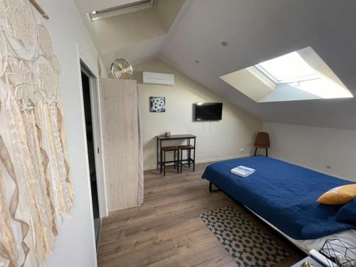 - une chambre avec un lit bleu et une table dans l'établissement Chambre Attrape rêves, à Sainte-Geneviève-des-Bois