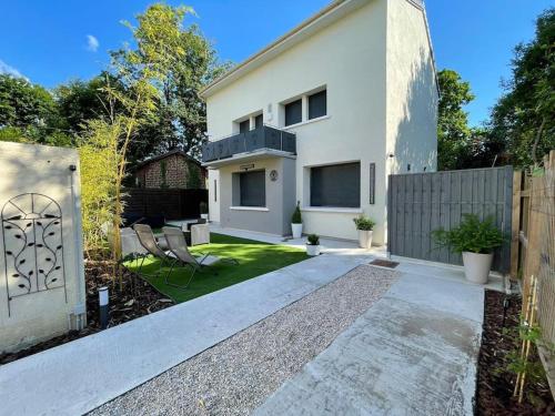 une maison blanche avec une clôture et une cour dans l'établissement Chambre Attrape rêves, à Sainte-Geneviève-des-Bois
