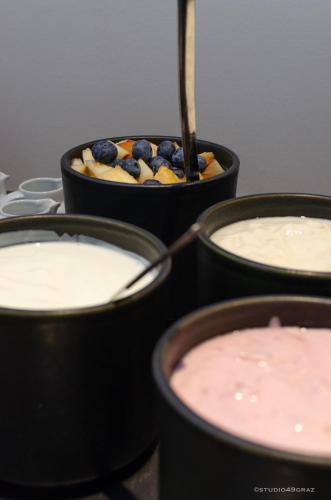 a group of four pots filled with yogurt and blueberries at IntercityHotel Graz in Graz