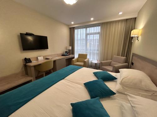 a hotel room with a large bed and a desk at Hotel Siesta in Užice