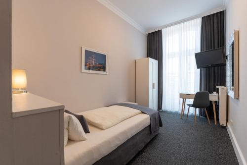 a hotel room with a bed and a desk at Hotel Commodore in Hamburg