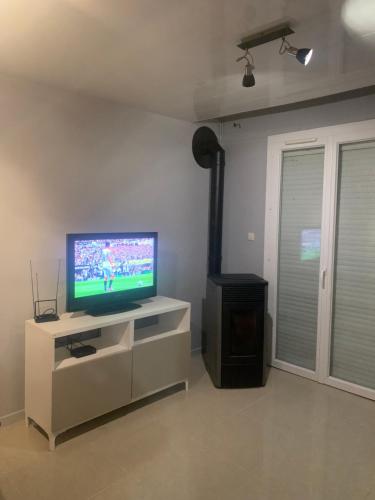 un salon avec une télévision à écran plat sur une armoire dans l'établissement Maison entière entre Orléans et Montargis, à Chailly-en-Gâtinais
