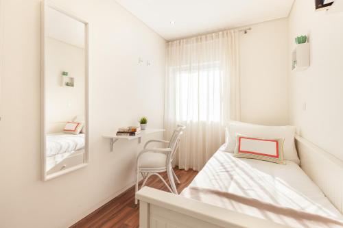 a white bedroom with a bed and a mirror at D&S - Torne Apartments in Vila Nova de Gaia