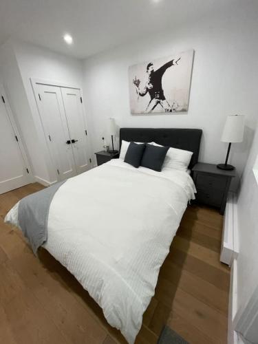 a white bedroom with a large bed with white sheets at Stunning Family Style Duplex in New York