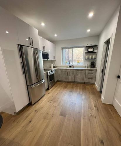 a kitchen with stainless steel appliances and wooden floors at Stunning Family Style Duplex in New York