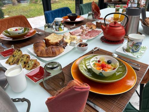 a table with a plate of breakfast food on it at Les Suites Champenoises in Reims