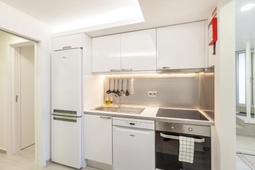 a kitchen with white cabinets and a sink at D&S - Torne Apartments in Vila Nova de Gaia