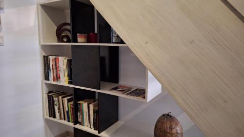 a book shelf under a staircase with books at Vacance et Cure dans Duplex 80 M2 à CERET 66400 in Céret
