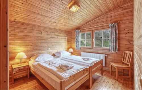 a bedroom with a bed in a wooden cabin at 2 Bedroom Nice Home In Masserberg in Masserberg