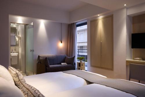 a hotel room with a bed and a chair at Domotel Olympia in Thessaloniki