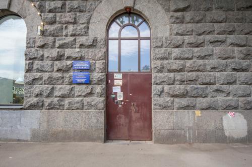 a brick building with a brown door and two windows at Idea Design Apart-Hotel Prorizna in Kyiv