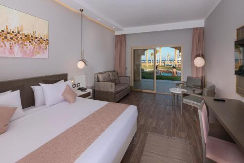 a hotel room with a bed and a chair at Sataya Resort Marsa Alam in Marsa Alam City