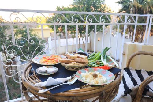 a table with plates of food on a balcony at Moka Gust House in Luxor