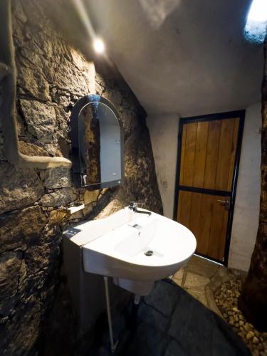 a bathroom with a sink and a stone wall at Forest Heaven Eco Resort in Belihuloya