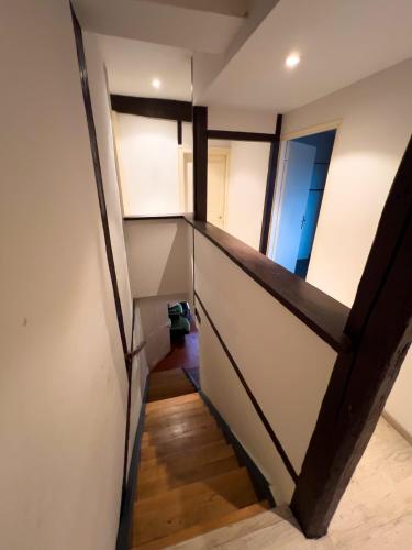 - un escalier dans une chambre dotée de murs blancs et de parquet dans l'établissement Chambre individuelle 2, à Ancerville