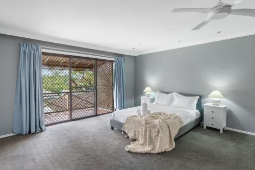 a bedroom with a bed and a large window at Spacious Affordable 7B3B 2 Living Pool Yard and Mall in Brisbane