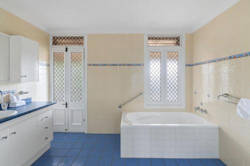 a white bathroom with a tub and a sink at Spacious Affordable 7B3B 2 Living Pool Yard and Mall in Brisbane
