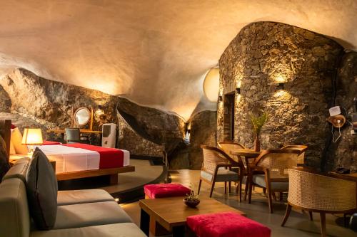 ein Hotelzimmer mit einem Bett und einer Felswand in der Unterkunft Forest Heaven Eco Resort in Belihuloya
