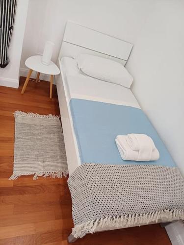 a white bed with a pillow and a chair in a room at Your nest at Colosseum!! in Rome