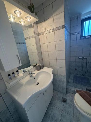 a white bathroom with a sink and a shower at ManiSpot BP in Areopoli