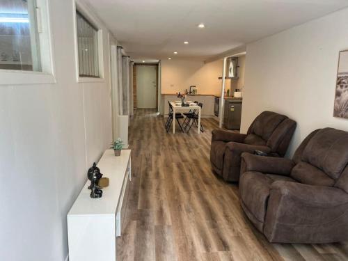 a living room with two chairs and a table at Cozy 2Beds Studio witch Kitchen Laundry near Zoo and Mall in Jindalee