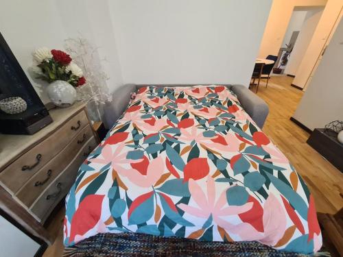 - un lit avec une couette en fleurs dans l'établissement La cigogne d'Alsace 2, à Sélestat