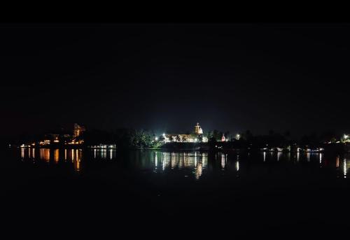 a night view of a building on a island in the water at Jaladarshini Lakeside Gardens in Kollam