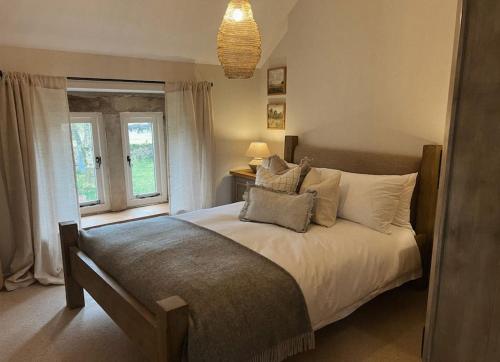 ein Schlafzimmer mit einem Bett mit Kissen und einem Fenster in der Unterkunft Primrose cottage in Buxton