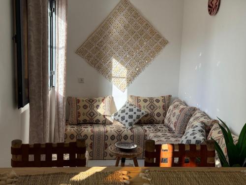 a living room with a couch and a window at L'étoile de taghazout in Taghazout