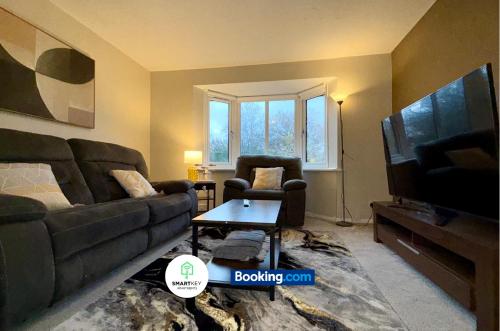 a living room with a couch and a tv at 2 Bedroom Ap Close to Woking town with Free Parking in Horsell