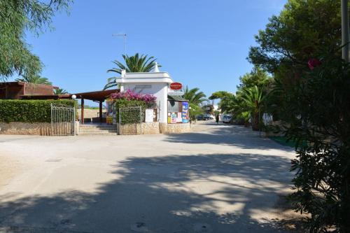 an empty street with trees and a building with a tree at Camping Villaggio Pineta Al Mare in Specchiolla 