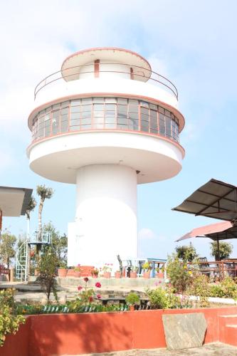 a lighthouse in front of a building at Daman View Tower Resort Pvt Ltd in Pālung