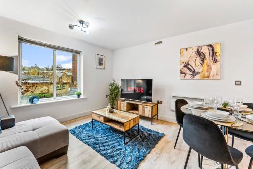 a living room with a table and a couch at 30 percent off! Stylish 2 Bed 2 Bath Abode with Parking in Dewsbury