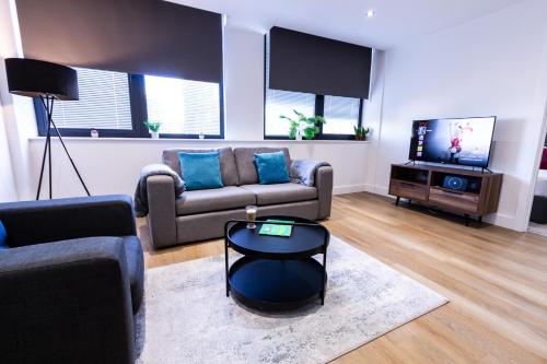 a living room with a couch and a tv at Trendy Apt in the Heart of MCR in Manchester