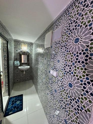 a bathroom with a sink and a mosaic wall at L'étoile de taghazout in Taghazout