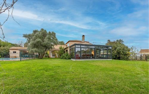 ein Glashaus in einem Hof mit einem Grasfeld in der Unterkunft Gorgeous Home In Montady in Montady