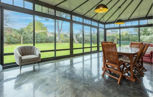 ein Wohnzimmer mit Tisch und Stühlen und Fenstern in der Unterkunft Gorgeous Home In Montady in Montady