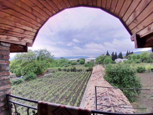 a view through an archway of a vineyard from a building at Château Fort de Manavi, Boutique Hotel in Manavi